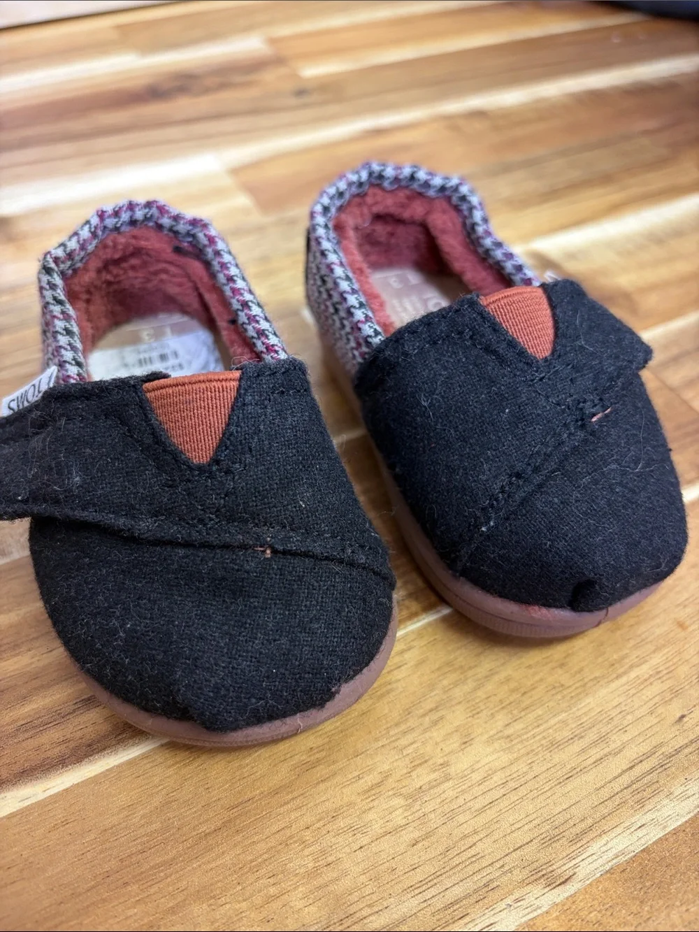 Toms Black Baby Slip-Ons with Rust Accent and Patterned Trim
